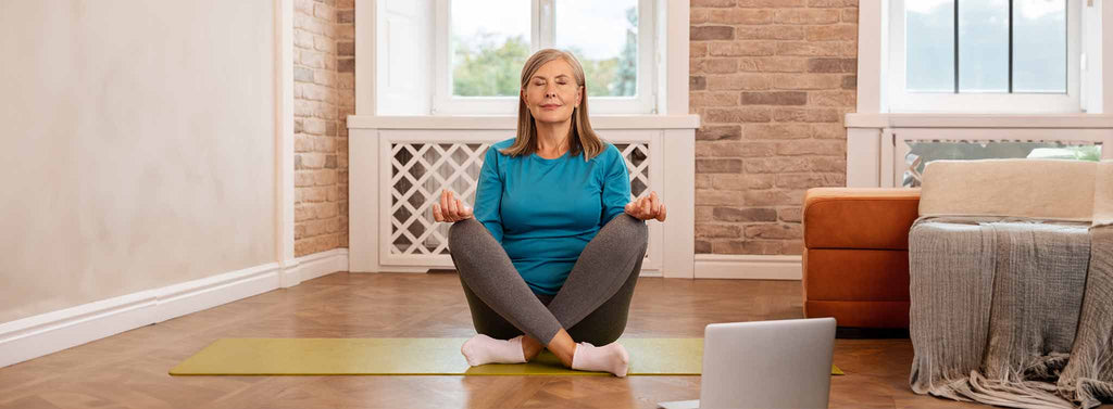 Elderly lady practicing mindfulness through meditating.