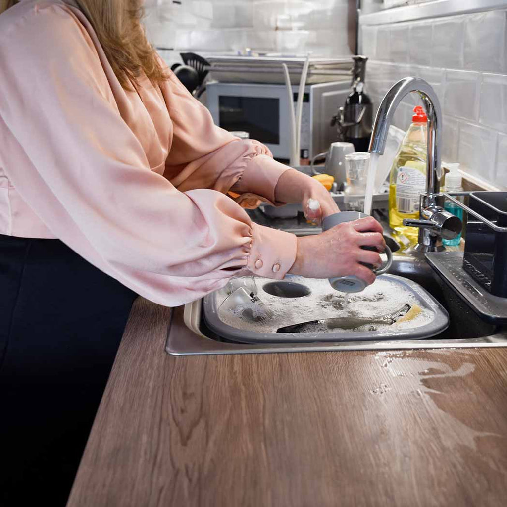 Women washing the dishes for an NDIS participant. 